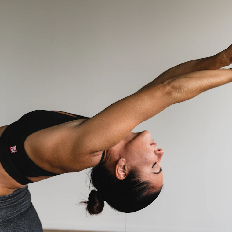 Close-up of a woman stretching through a backbend during a wellness session