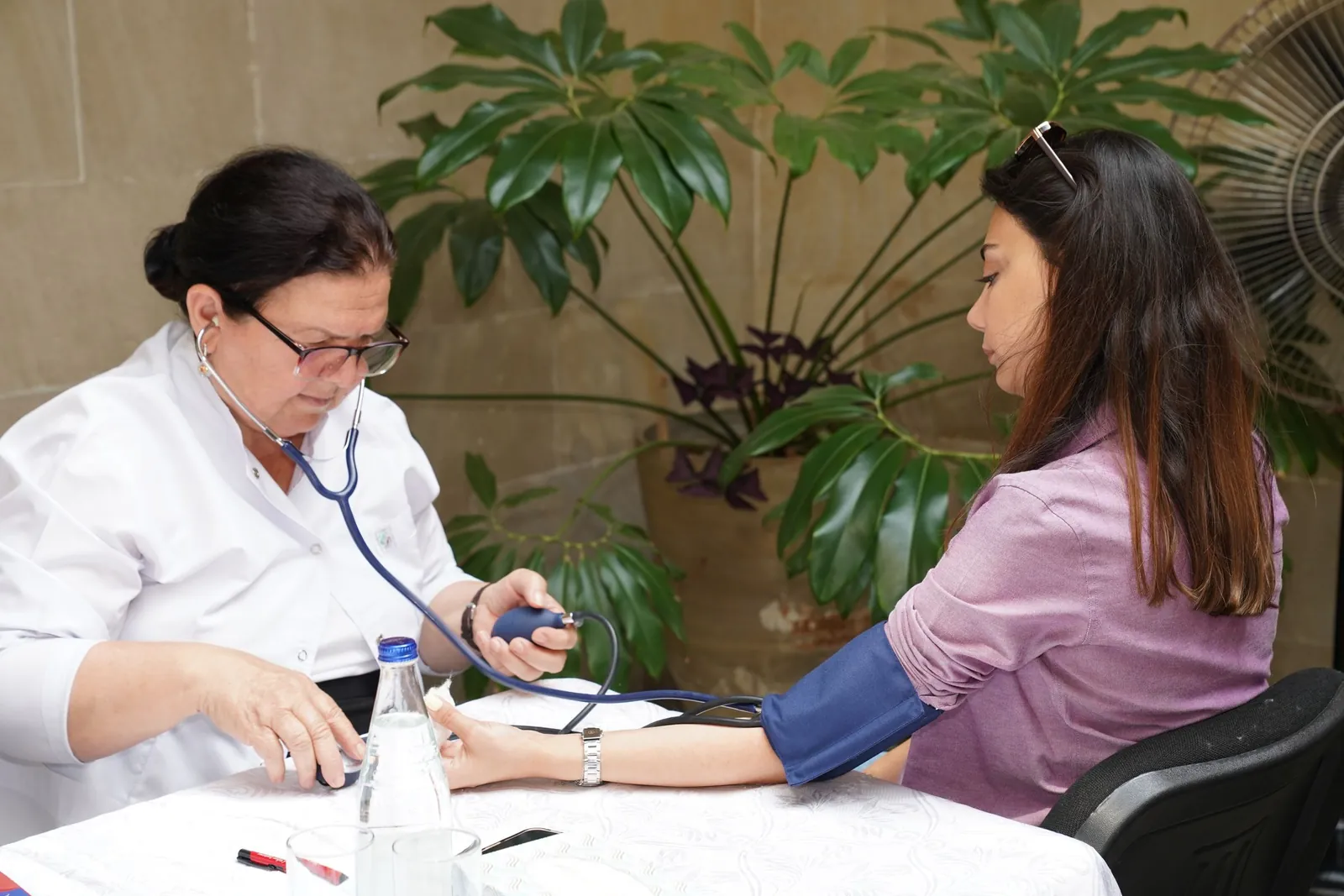 Healthcare professional checking an employee's blood pressure during a workplace preventive health camp