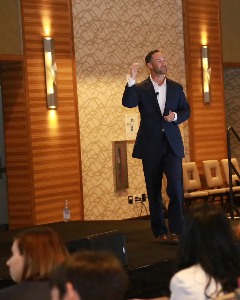 Confident speaker addressing an audience from a conference stage