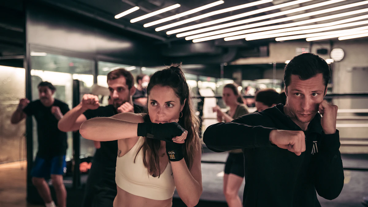Mixed group practicing guided self-defence stances in a modern studio