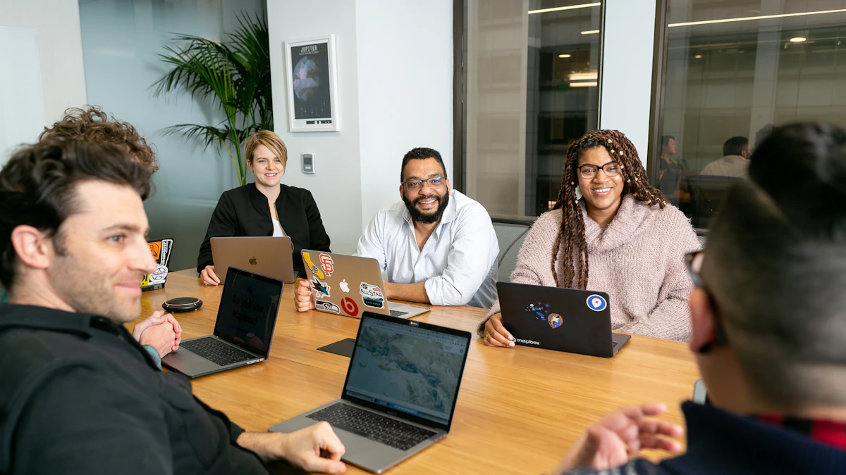Diverse team of colleagues collaborating together around laptops